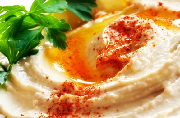 Bowl of hummus topped with paprika. Traditional chickpea dip.